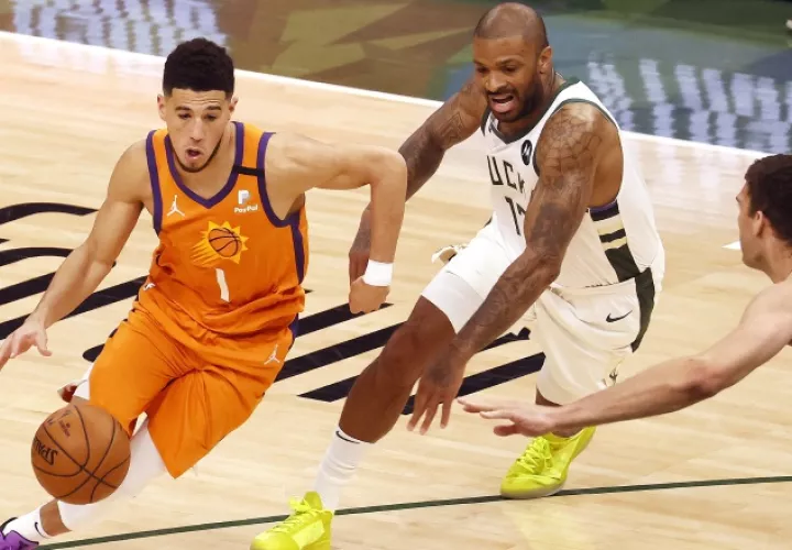 Devin Booker de los Suns (izq.) es marcado por P.J. Turcker. Foto:EFE