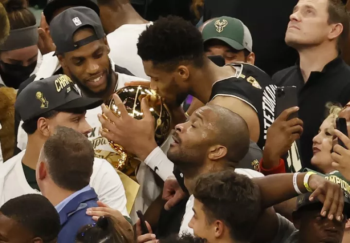 Giannis Antetokounmpo besa junto a Larry O'Brien el trofeo de campeón de la NBA. Foto.EFE