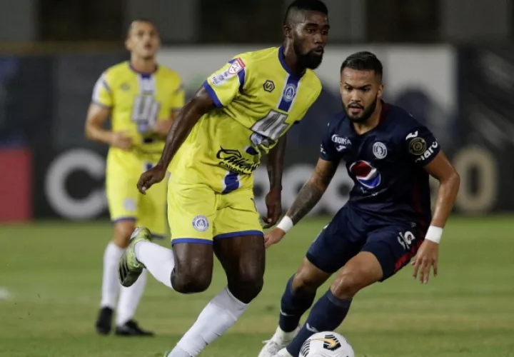 Everardo Rose  de Universitario (izq.) disputa un balón contra Omar Elvir de Motagua. Foto:EFE