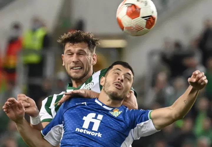 Guido Rodríguez del Real Betis (frente) salta a disputar el balón contra Balint Vecsei de Ferencvaros. Foto:EFE  