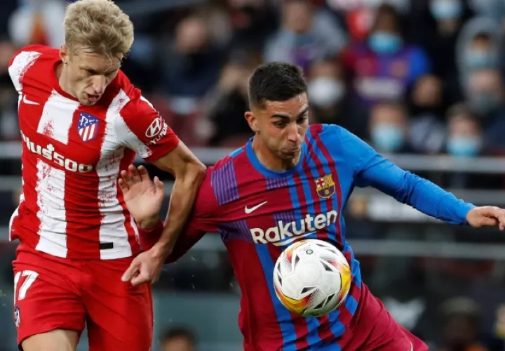 Los jugadores Daniel Wass del Atlético y Ferrán Torres (der.) del Barcelona, disputan el balón durante el partido. EFE