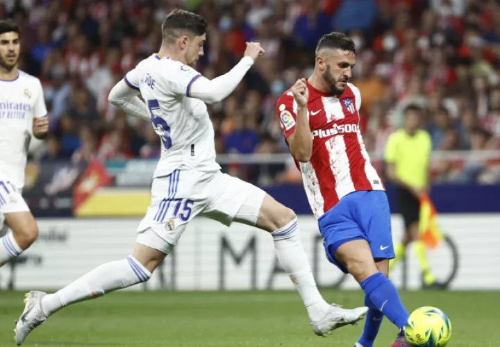 Koke (der.) golpea el balón ante Fede Valverde del Real Madrid. Foto:EFE