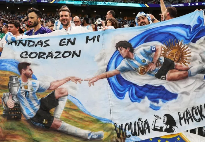 2-  Aficionados de Argentina con una imagen de Maradona y Leo Messi