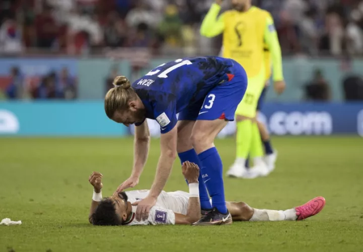 Tim Ream de Estados Unidos (azul)  intenta consolar y levantar a  Ramin Rezaeian de Irán Foto:EFE