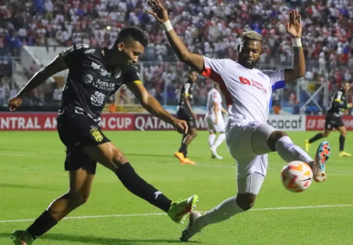 Sergio Ramírez del CAI (izq.), despeja el balón ante la llegada de Jorge Benguché del Olimpia. Foto:EFE