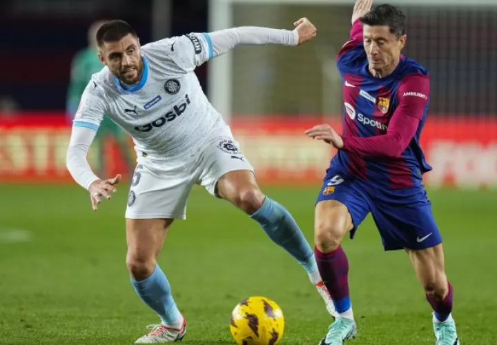 El delantero polaco del  Barcelona, Robert Lewandowski (der) disputa el balón ante David López, del Girona. Foto:EFE