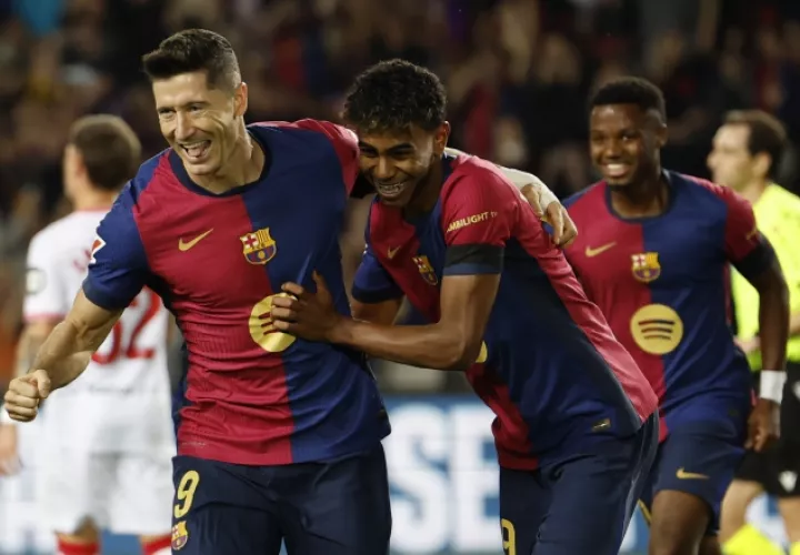 Robert Lewandowski (izq) celebra con Lamine Yamal el primer gol del Barcelona contra Sevilla. Foto: EFE