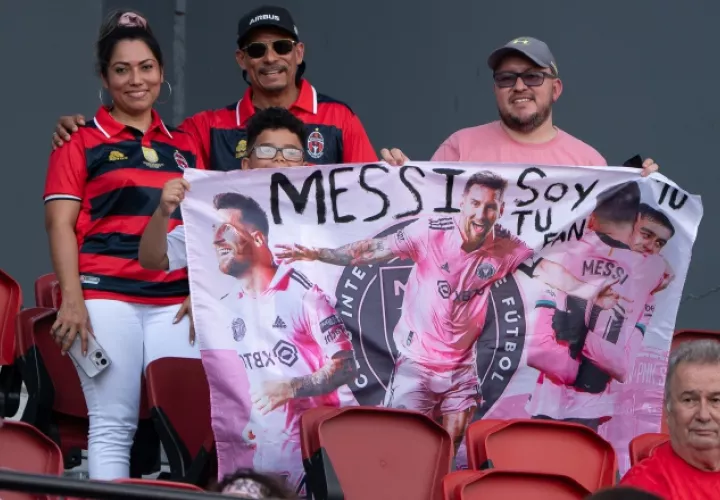 Aficionados sostienen un cartel de Lionel Messi. Foto:EFE