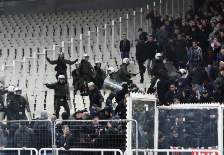 Policías griegos tratan de controlar a aficionados de Ajax. Foto EFE