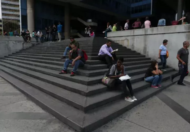  Venezolanos permanecen a la entrada de un edificio durante el apagón eléctrico en Caracas (Venezuela). Foto: EFE.