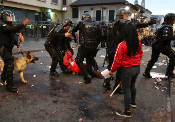  Policías se enfrentan a manifestantes durante una protesta de apoyo a favor del australiano Julian Assange, en Quito. Foto: EFE.