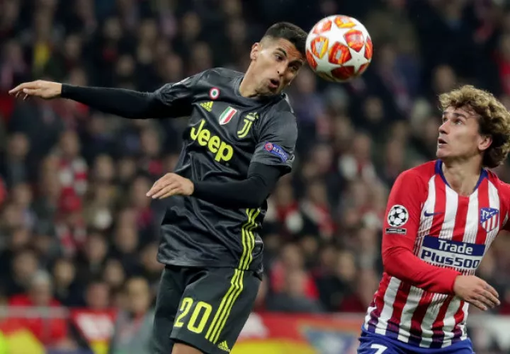 El defensa de la Juventus, Joao Pedro Cancelo (izq.) cabecea el balón ante el delantero del Atlético de Madrid, Antoine Griezmann. Foto:EFE