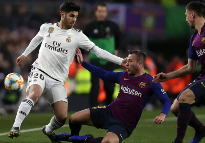 Marco Asensio de Real Madrid (izq.) es marcado por  Arthur del Barcelona. Foto:AP