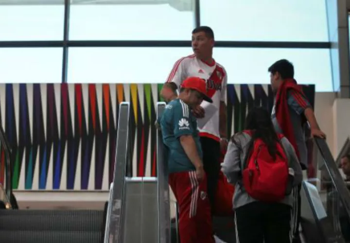 Hinchas del Boca Juniors y River Plate esperan en el Aeropuerto Internacional de Ezeiza para viajar a Madrid. Foto EFE