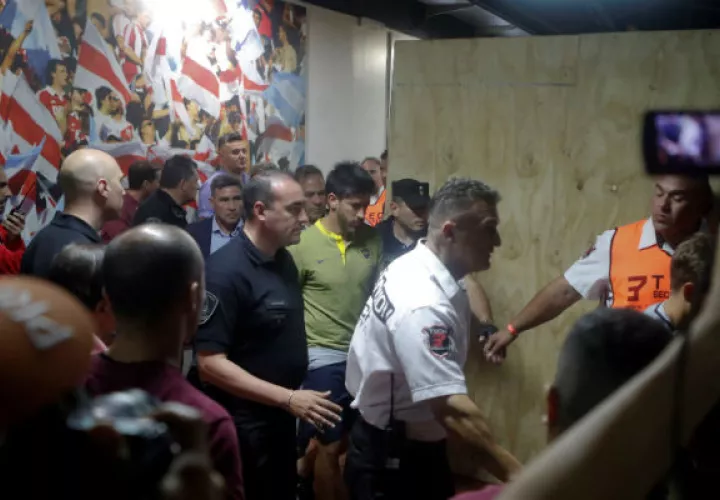 El jugador de Boca Juniors Pablo Pérez (cent.) sale acompañado por médicos. Foto:EFE
