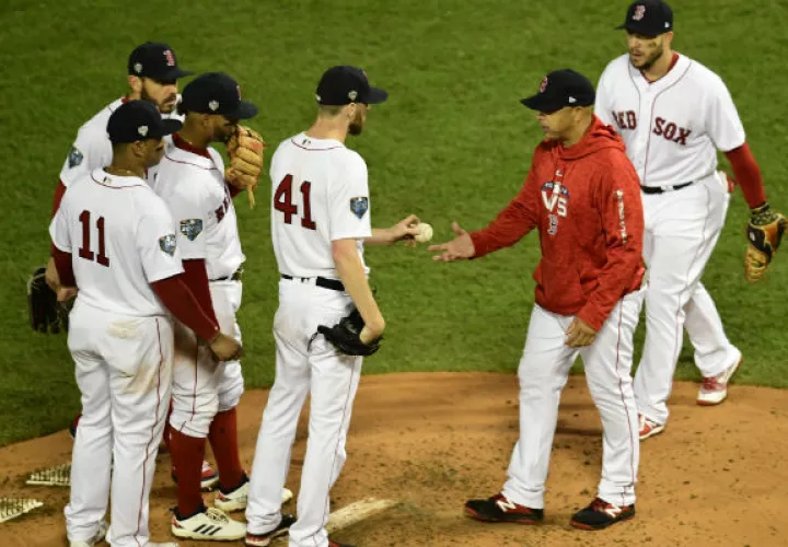 El lanzador de los Medias Rojas Chris Sale (cent.) entrega la pelota el entrenador Alex Cora (rojo). Foto:EFE