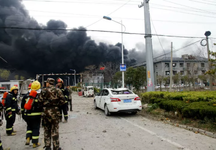 Bomberos en las afueras de la fábrica siniestrada. Foto: AP.