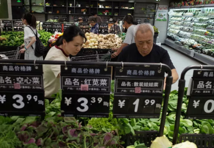 Compradores seleccionan verduras en un supermercado en Pekín (China). Foto: EFE.