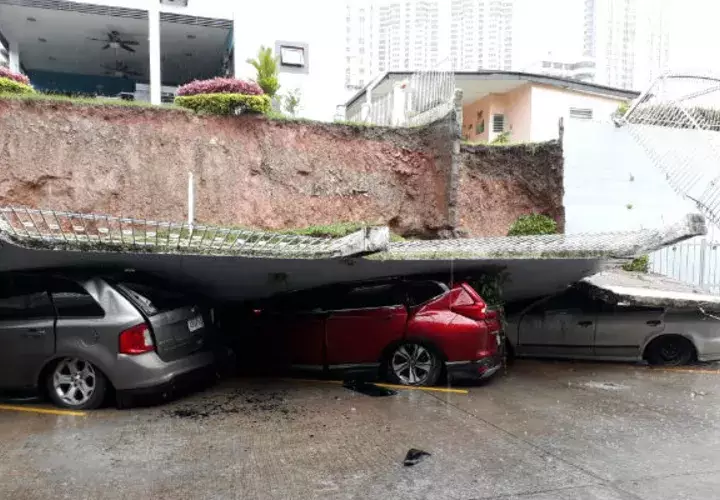 El muro le cayó encima a los autos en el estacionamiento.