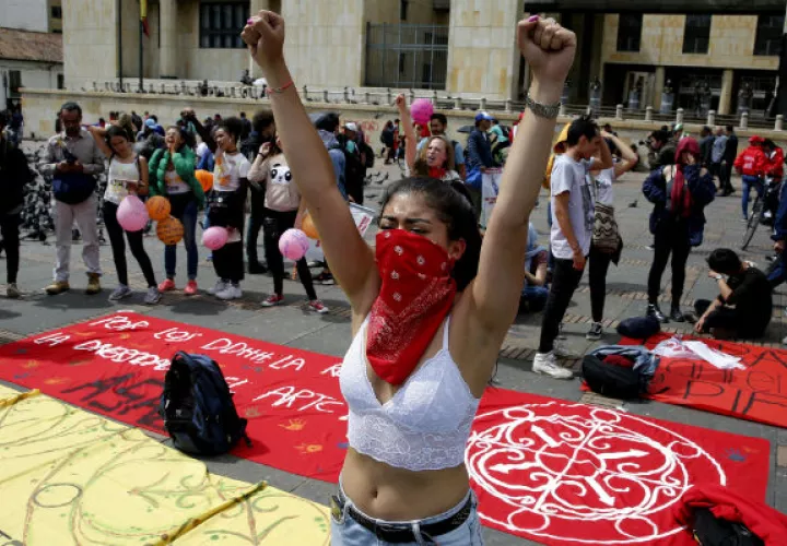 Una manifestante con el rostro cubierto en la jornada de Paro Nacional en la Plaza de Bolívar, en Bogotá. Foto. EFE.