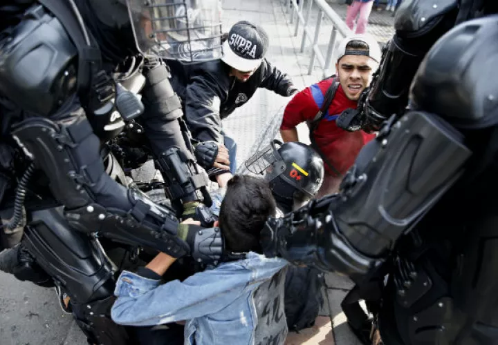 Manifestantes se enfrentan a policías durante la manifestación en Bogotá. EFE