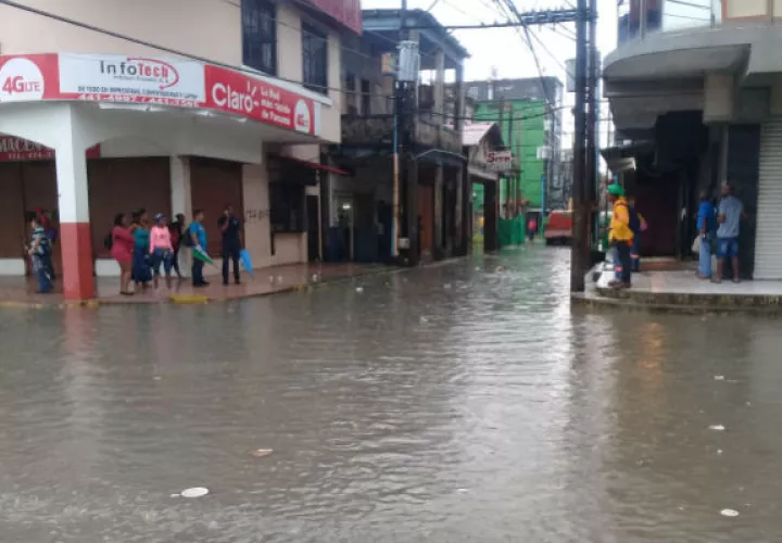 Los residentes se las tienen que ingeniar para poder cruzar la vía por las inundaciones en Colón. 