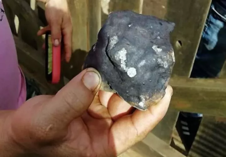Una persona muestra restos del meteorito caído. Foto: AP.