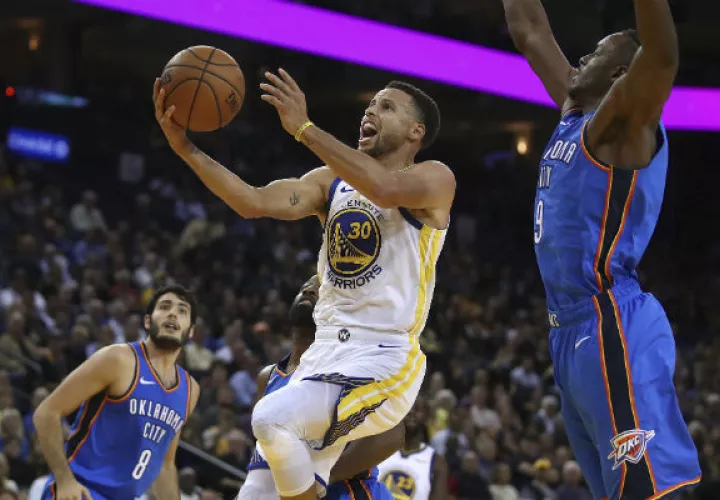 Stephen Curry (30) de los Golden State Warriors anota una canasta  ante la marca de Jerami Grant de Oklahoma. Foto:AP