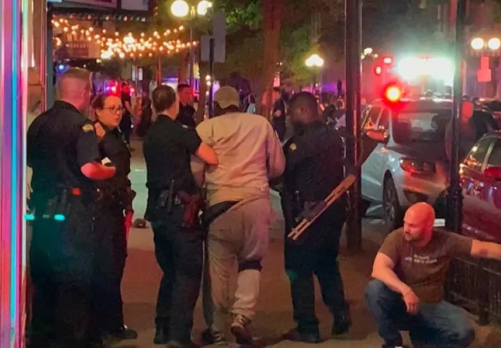 Los socorristas ayudan a caminar a una persona herida después de un tiroteo mortal en Dayton. FOTO/AP