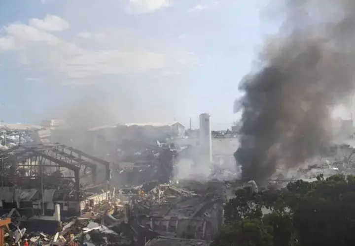 Miembros del cuerpo de bomberos trabajan entre los escombros que dejó una fuerte explosión en una fabrica de plásticos, en el sector Villas Agrícolas, en Santo Domingo. FOTO/EFE