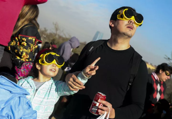 Cientos de personas acudieron a lo alto del Cerro San Cristóbal para observar el eclipse solar, en Santiago (Chile). Foto:EFE.