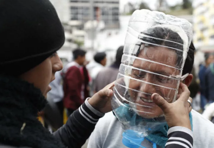 Manifestantes usan máscaras antigas elaboradas por el ecuatoriano Cesar Viteri este jueves en Quito.  Foto: EFE.