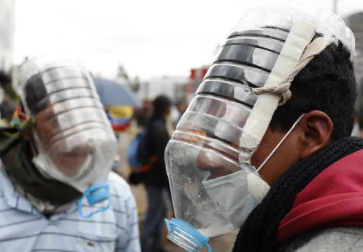 Manifestantes usan máscaras antigas elaboradas por el ecuatoriano Cesar Viteri este jueves en Quito.  Foto: EFE.