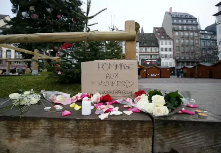 Flores y velas son depositadas en el lugar donde falleció una de las víctimas en el atentado en Estrasburgo (Francia). EFE
