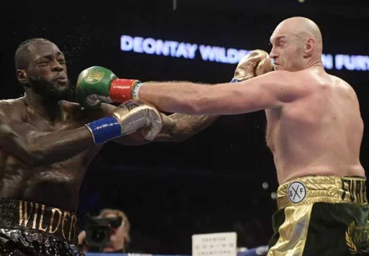 Deontay Wilder (izq.) intercambia golpes contra el británico Tyson Fury. Foto:AP