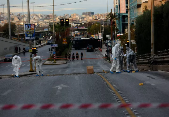 Agentes de la policía forense investigan el escenario de la explosión de una bomba frente al edificio de la cadena de televisión Skai, en Grecia. EFE