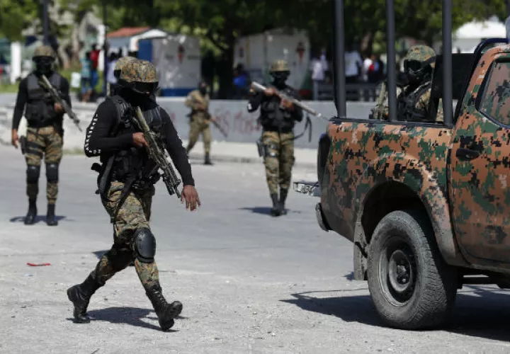 Guardias presidenciales custodian un convoy que transporta al presidente Jovenel Moise. Foto. AP.