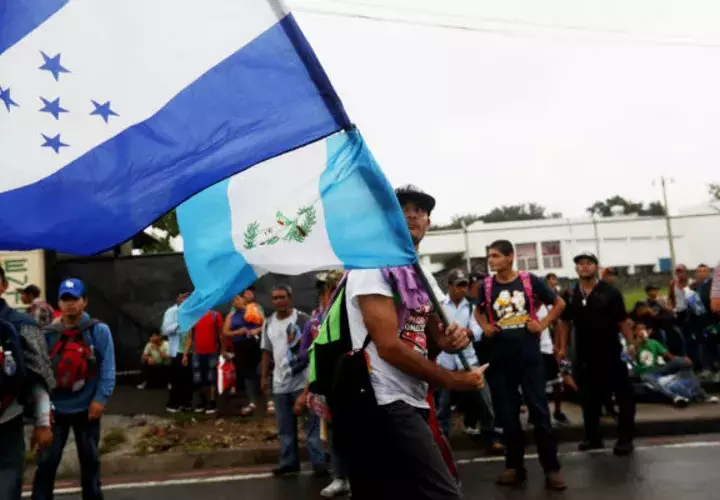  Un migrante hondureño ondea las banderas de Guatemala y Honduras durante su trayecto en la caravana de migrantes. EFE