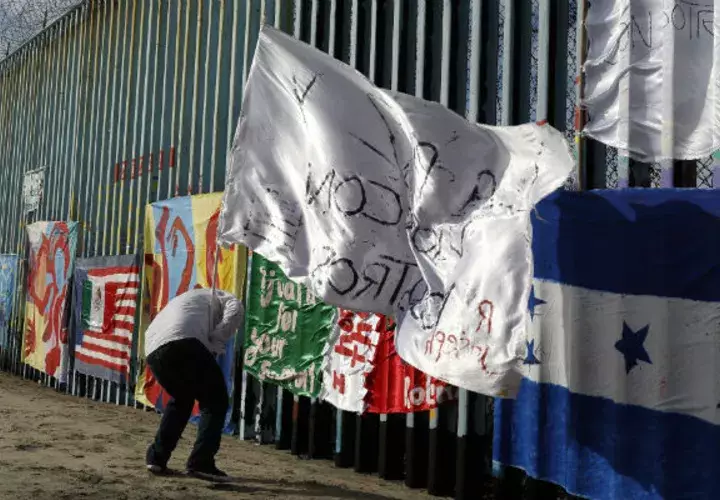 Un migrante hondureño frente a la valla entre Tijuana (México) y EE.UU. Foto: AP. 