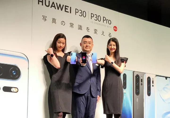 Un experto tecnológico de Huawei Wu Bo (c) muestra uno de sus productos en Tokio. Foto: EFE.