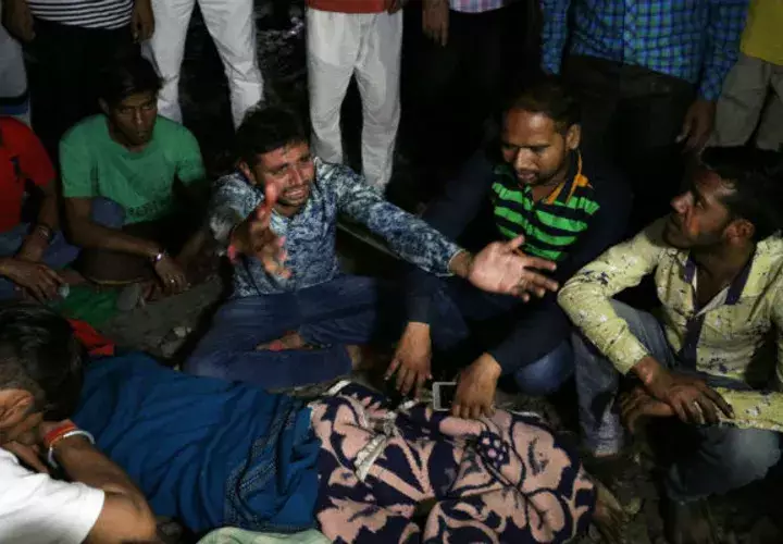 Parientes de las víctimas lloran junto a sus cuerpos tras el accidente de tren en Amritsar (India). EFE
