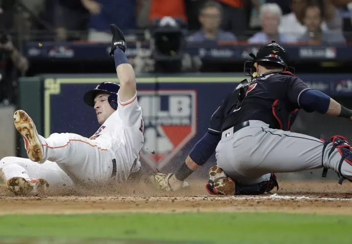 Alex Bregman (2) anota ante el intento de ponerlo fuera el receptor Yan Gomes. Foto AP