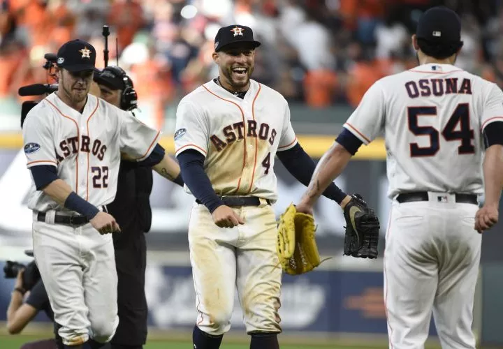 Josh Reddick (22), George Springer (4) y Roberto Osuna (54) celebran la victoria de Houston. Foto AP