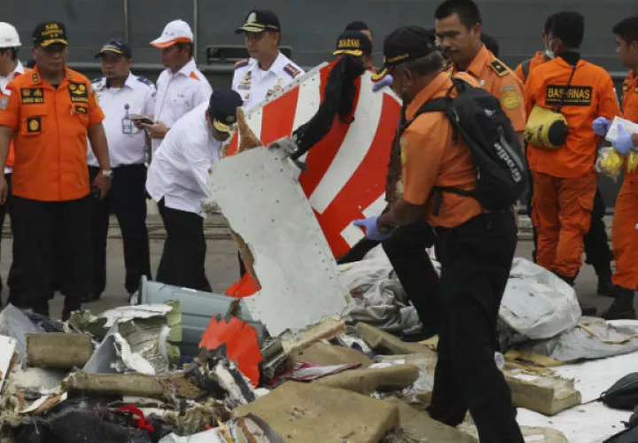 Un rescatista inspecciona una parte del vuelo recuperado de las aguas en Indonesia. AP