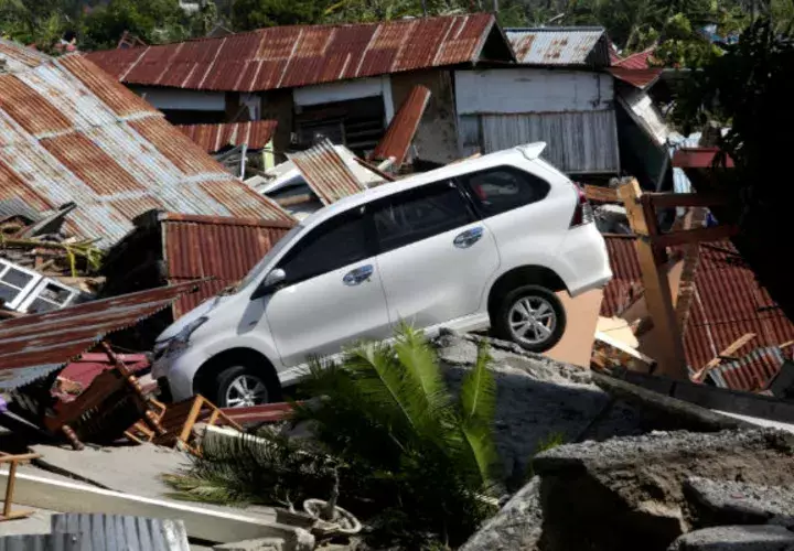 Un coche es visto sobre las ruinas de una casa tras el terremoto y posterior tsunami en Indonesia. EFE