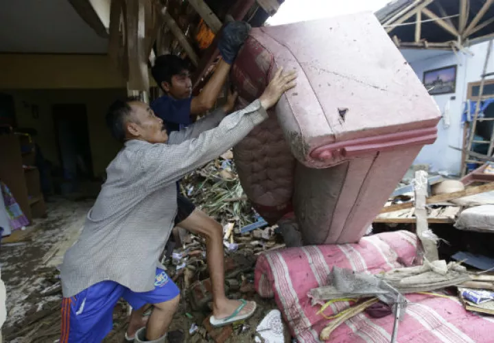 Los residentes limpian los escombros de las casas luego del tsunami en Carita, Indonesia. AP