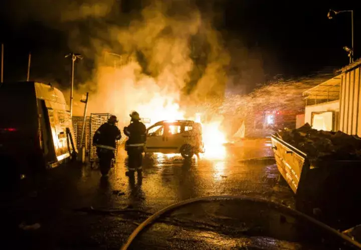 Bomberos israelíes sofocan el fuego de un auto bombardeado por Hamas. Foto: AP.