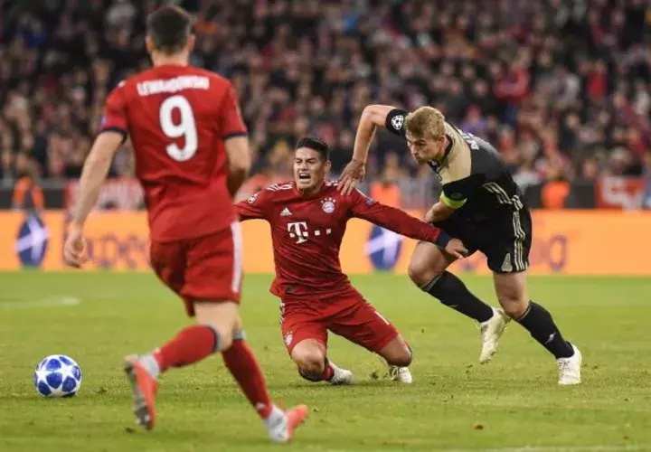 James Rodriguez (c) del Bayern de Múnich reacciona ante Matthijs de Ligt (d) del Ajax en un partido de la Champions. Foto EFE