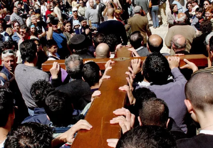 Un grupo de peregrinos lleva un cruz en su camino hacia la Basílica del Santo Sepulcro. Fotos: EFE
