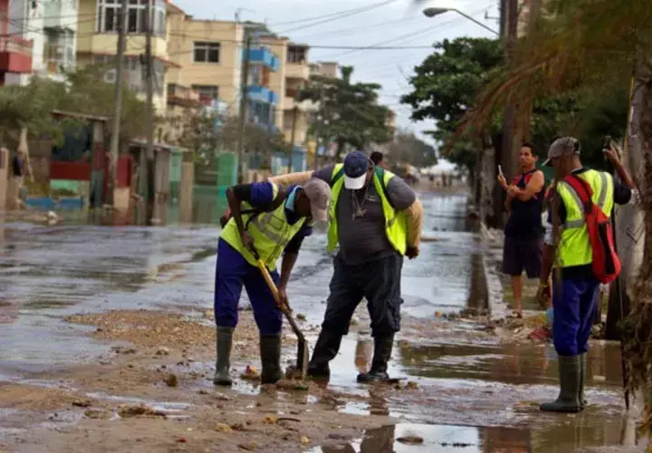 - Empleados trabajan para recuperar una calle inundada, debido a fuertes vientos e intensas marejadas en La Habana. FOTO/EFE